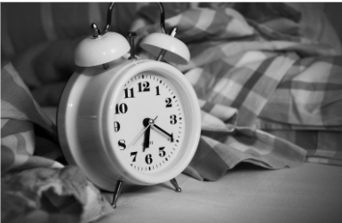 Sort/hvid billede med et alarmur på. God søvn er godt for vores fysiske velvære og god selvomsorg.